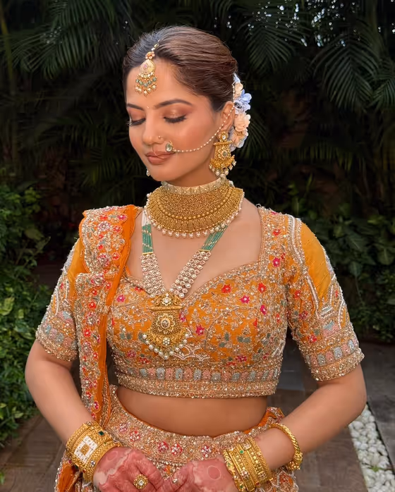 Orange lehenga with a soft eye and floral hair accessory
