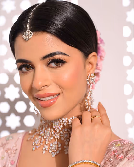 Sleek bun and statement diamond earrings with a glossy nude lip