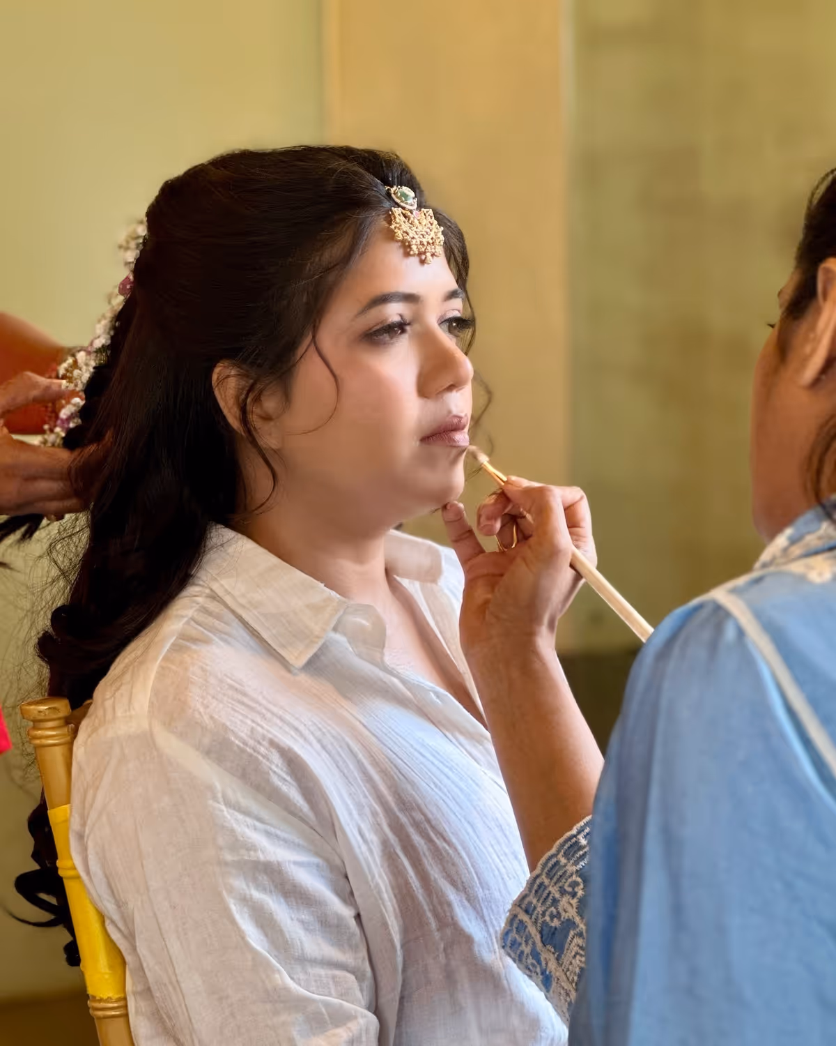 Kareizma applying lip colour on a client at a bridal morning